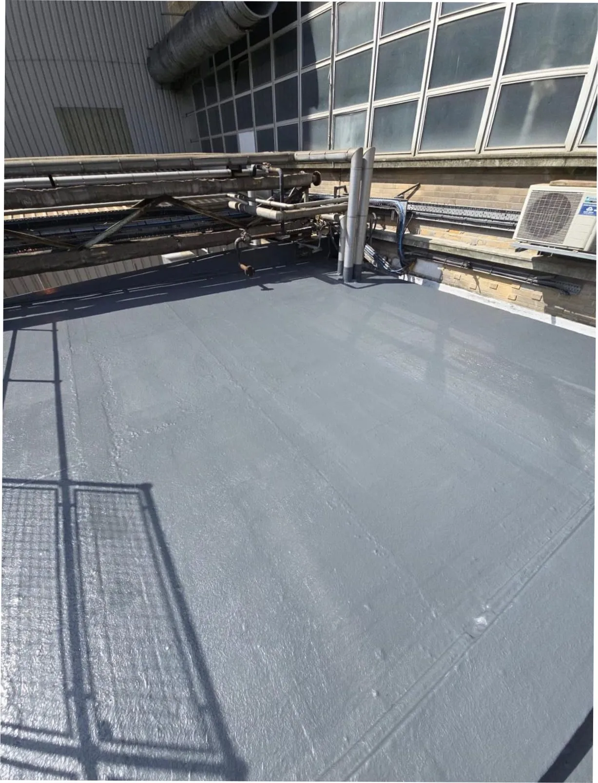 Freshly applied liquid roof coating on an industrial flat roof (illustrative)