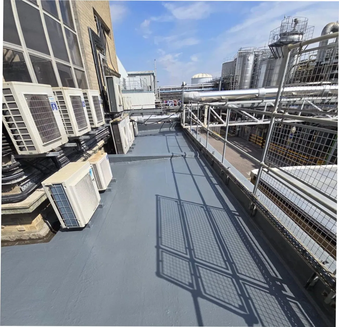 Completed liquid-coated roof walkway at an industrial plant (illustrative)