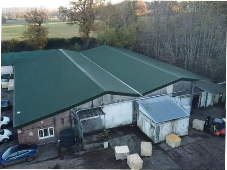 Aerial view of a re-coated industrial roof finished in green (illustrative)