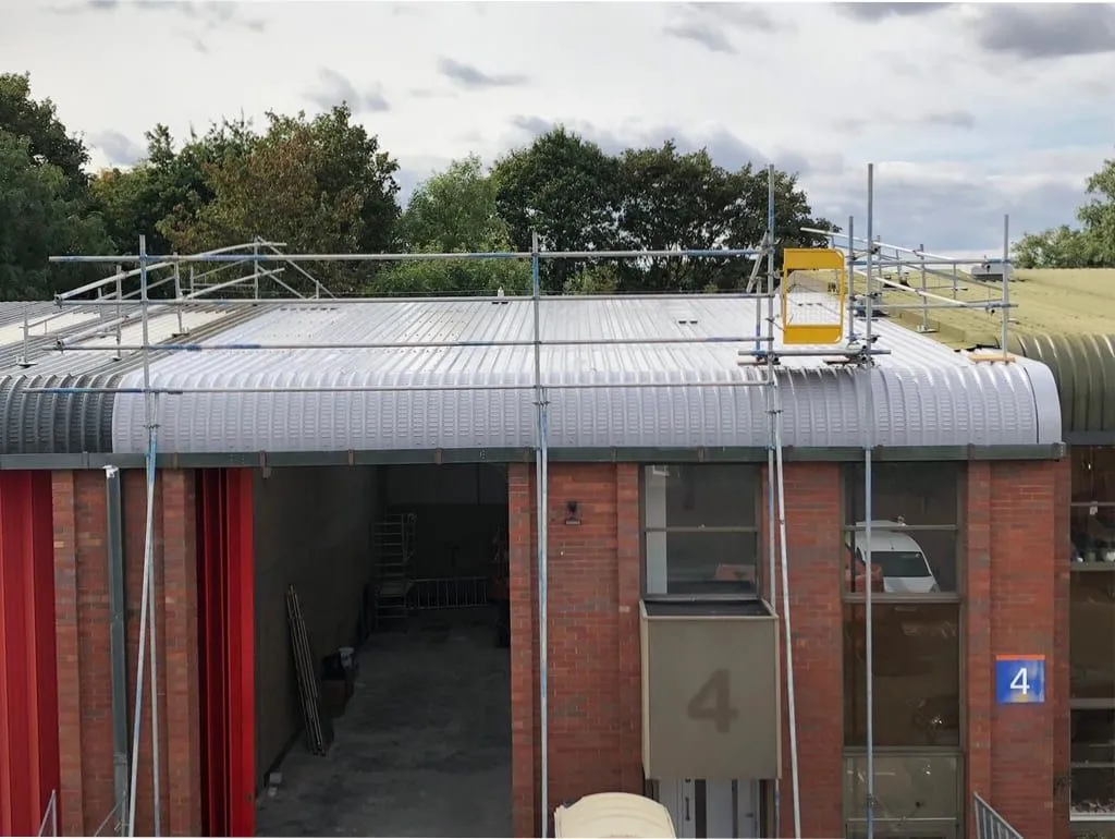 Newly installed curved metal roof sheets on an industrial unit (illustrative)